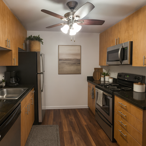 A kitchen with wooden cabinets and a black fridge.