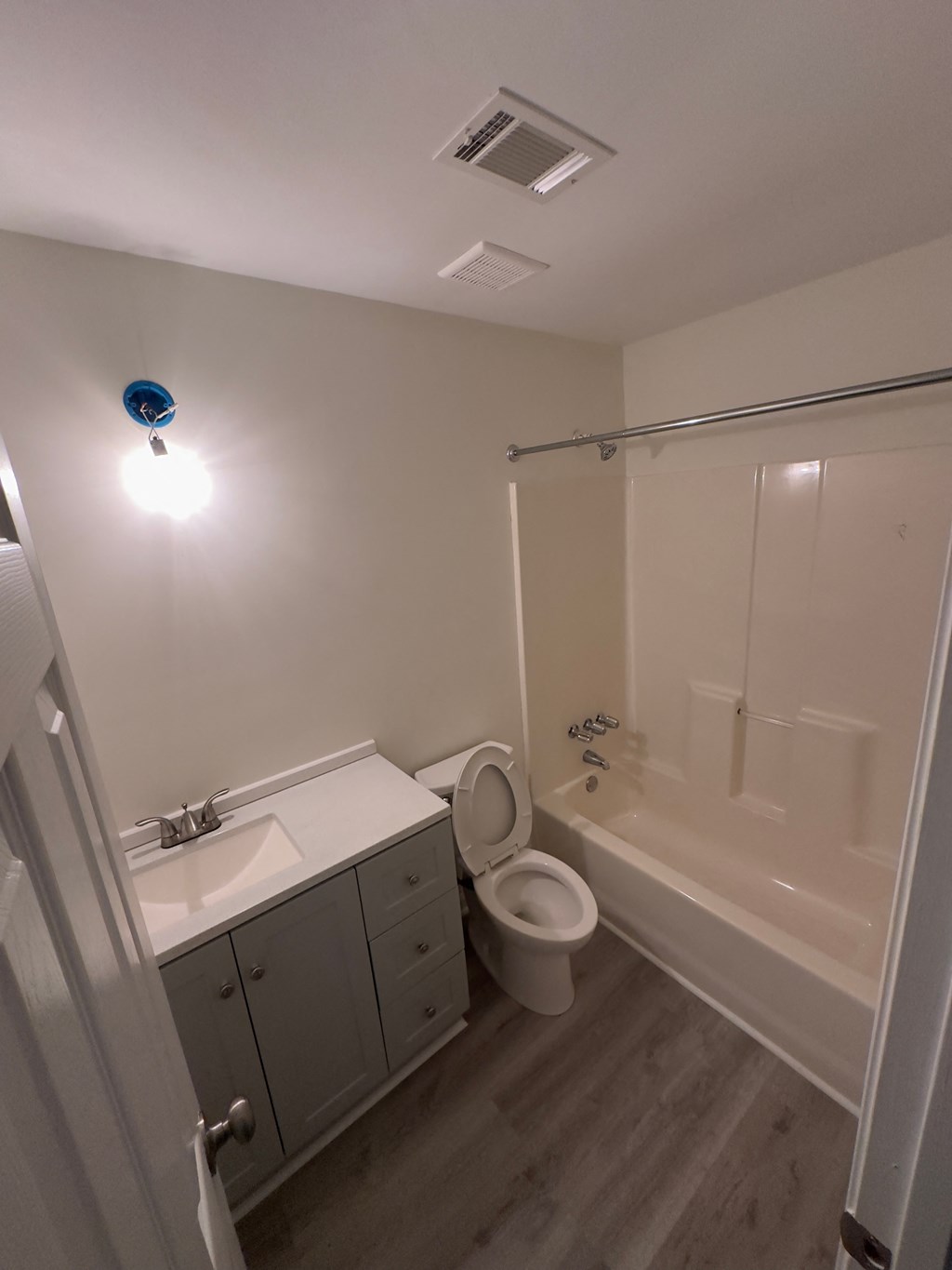 A bathroom with a toilet, sink, and shower.