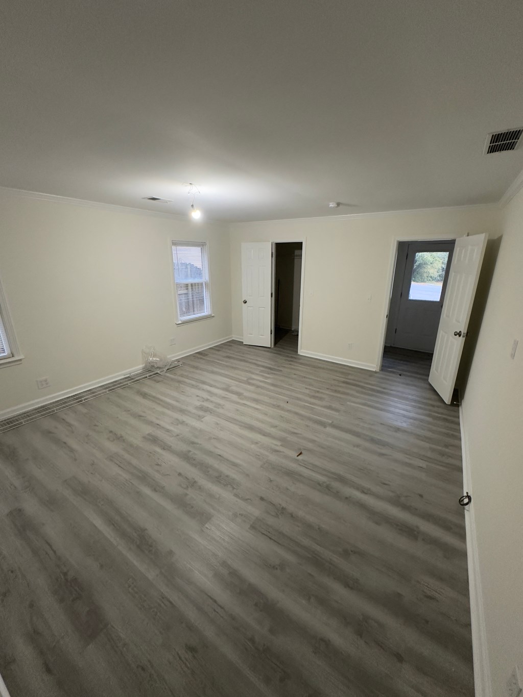 A room with wooden flooring and white walls.