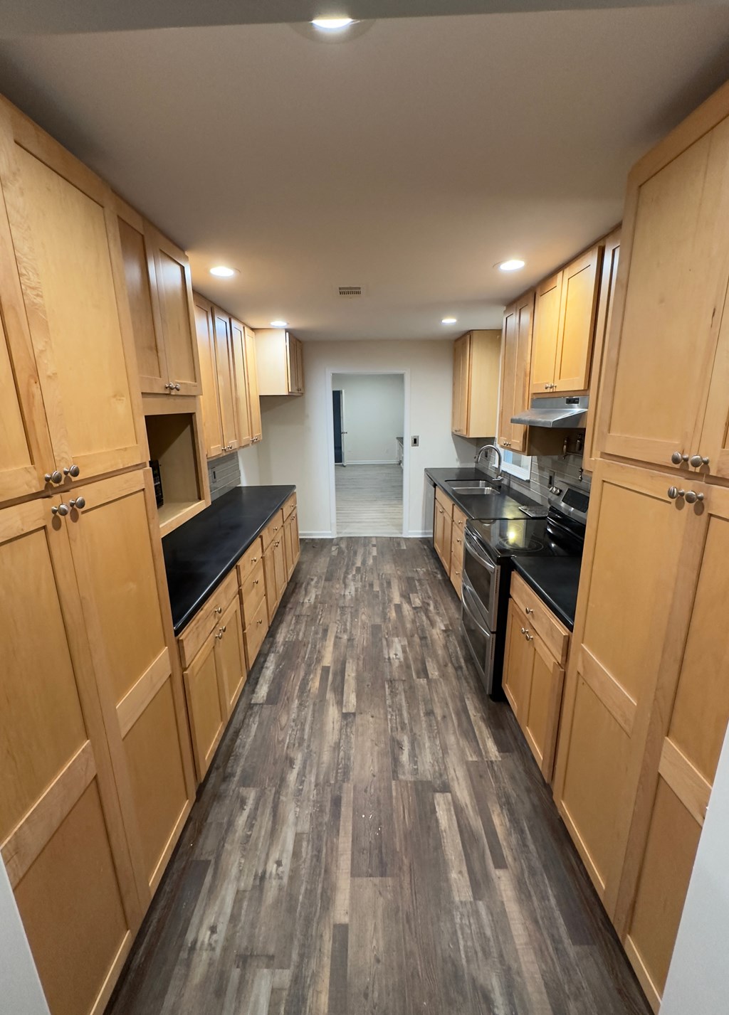 A long hallway with wooden cabinets on both sides.