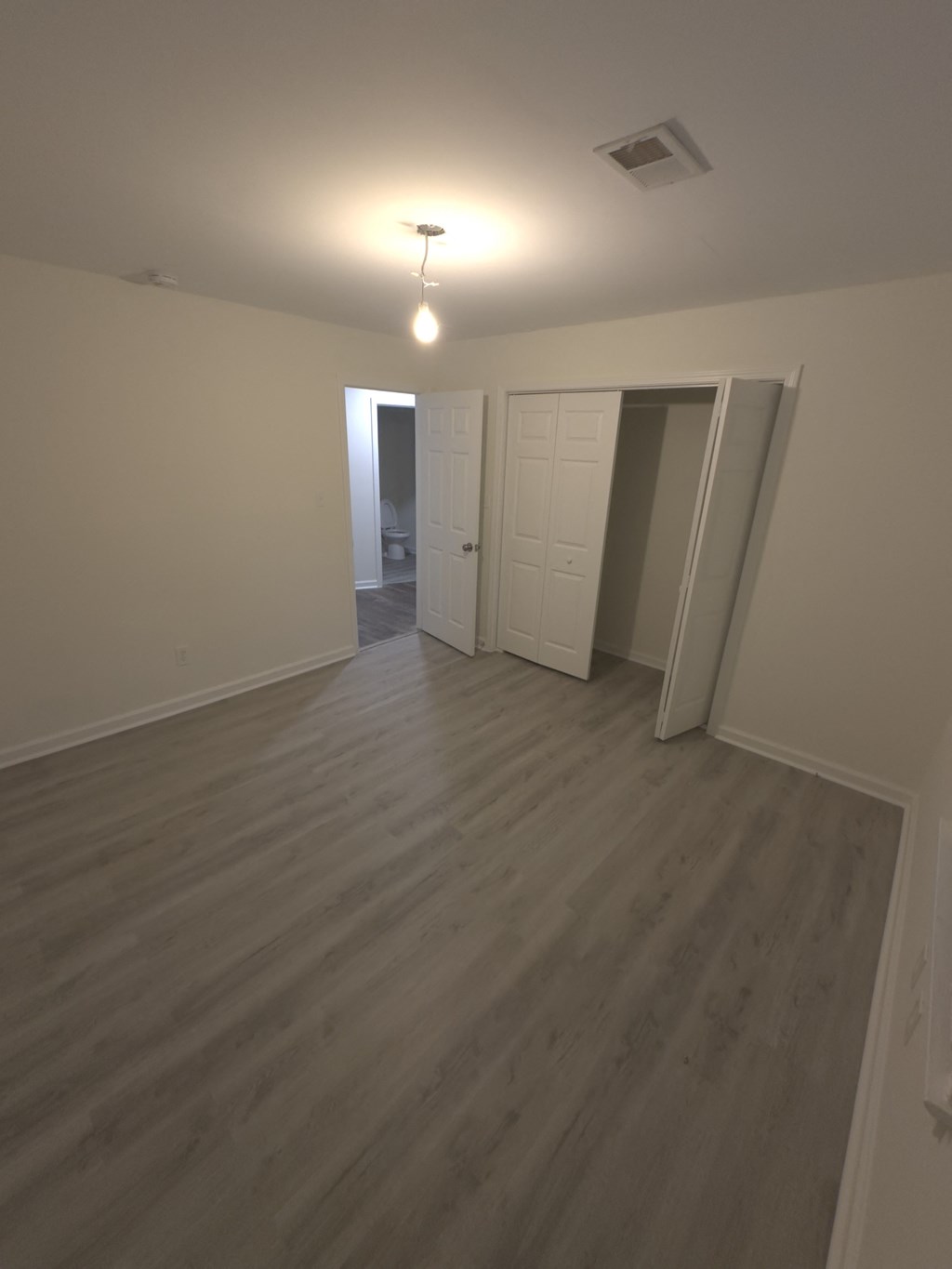 A room with a light on and a door at the end.