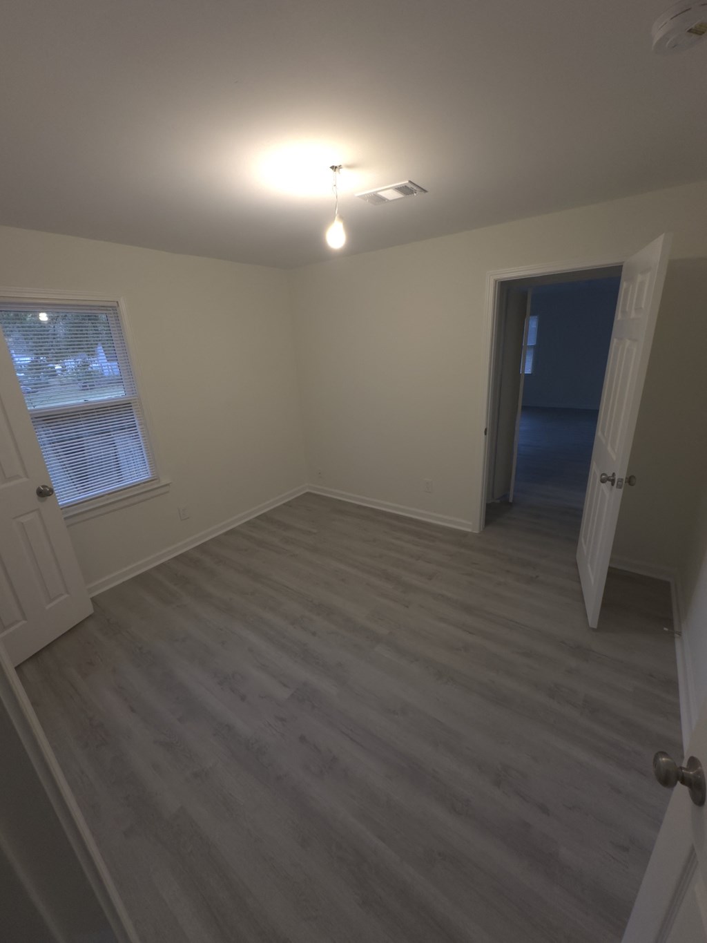 A room with a grey carpet and a white door.