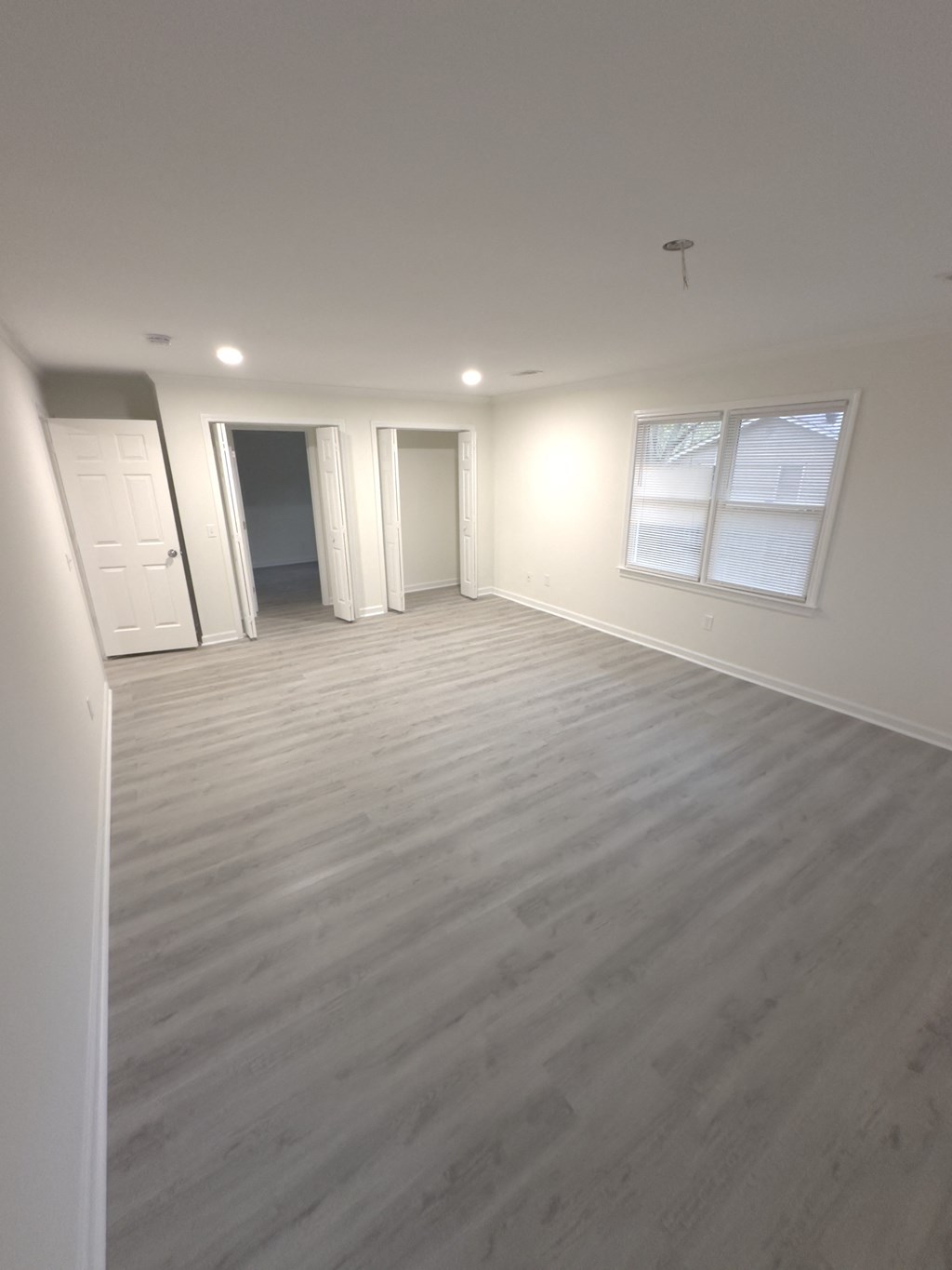 A room with light grey flooring and white walls.