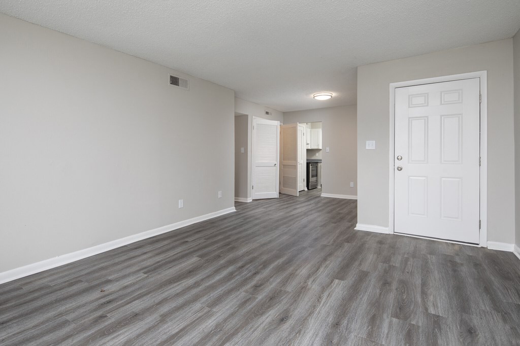 A room with a white door and a grey floor.