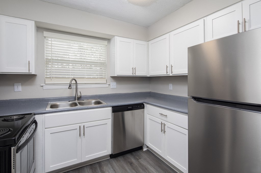 A kitchen with white cabinets and stainless steel appliances.