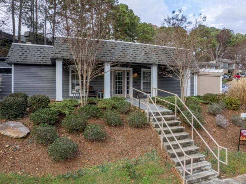 A house with a grey roof and a staircase leading to the front door.