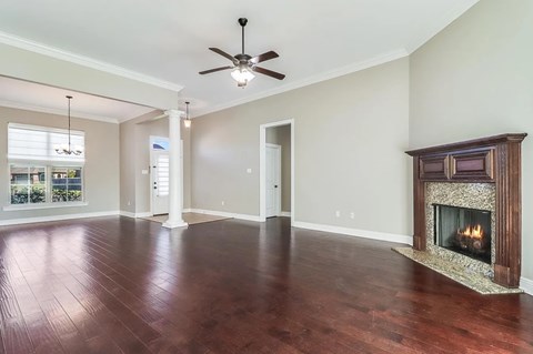 A living room with a fireplace and a ceiling fan.