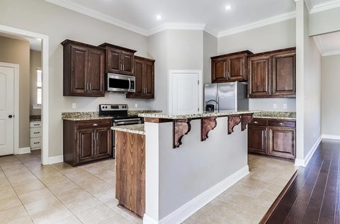A kitchen with brown cabinets and a white island.