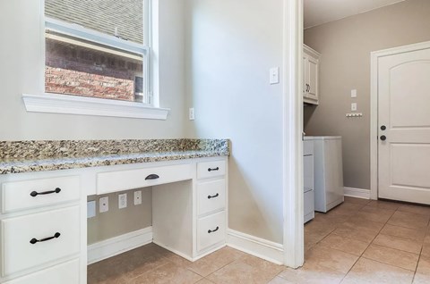 A kitchen with white cabinets and a granite countertop.