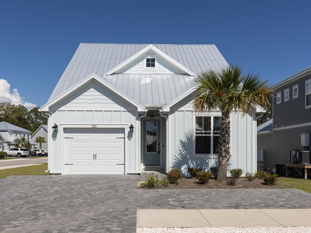 A house with a grey roof and a white garage door.