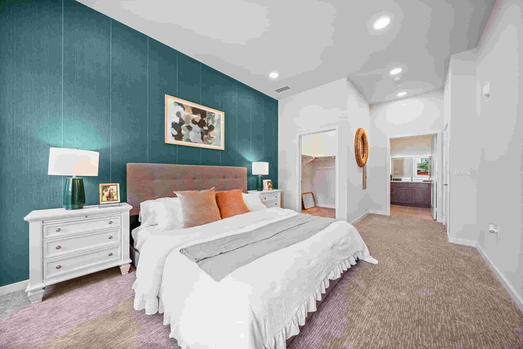 A bedroom with a large bed and a white dresser.