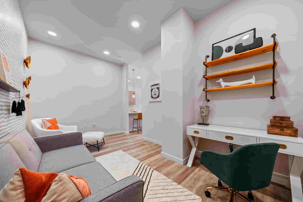 A living room with a grey couch and a green chair.