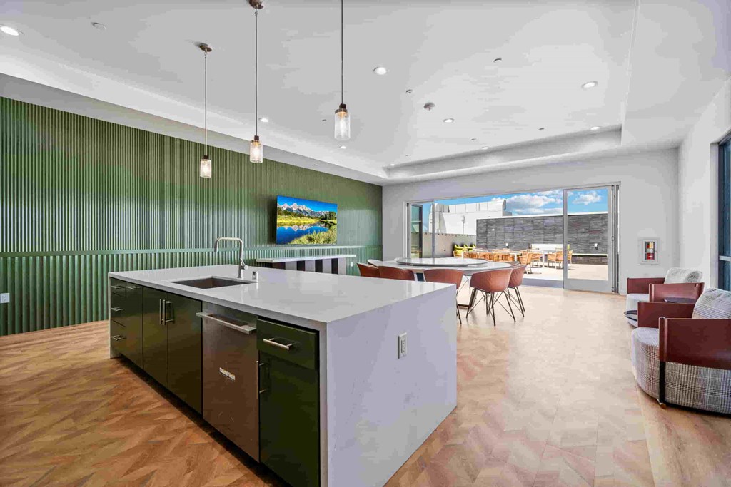 A modern kitchen with a white countertop and black cabinets.