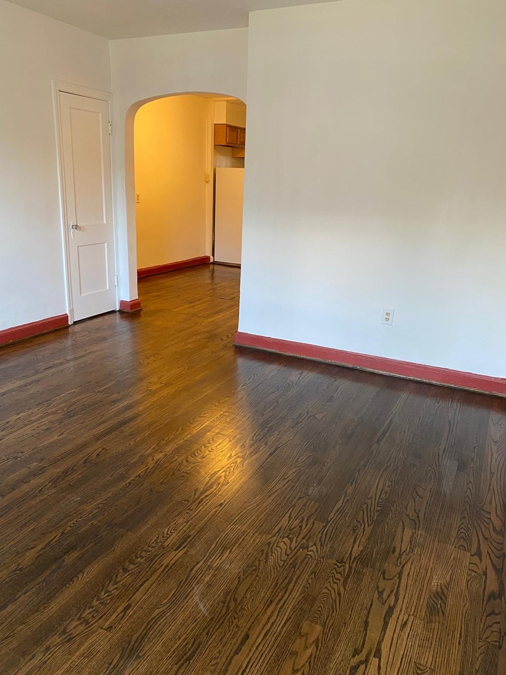 A room with a wooden floor and a white door.