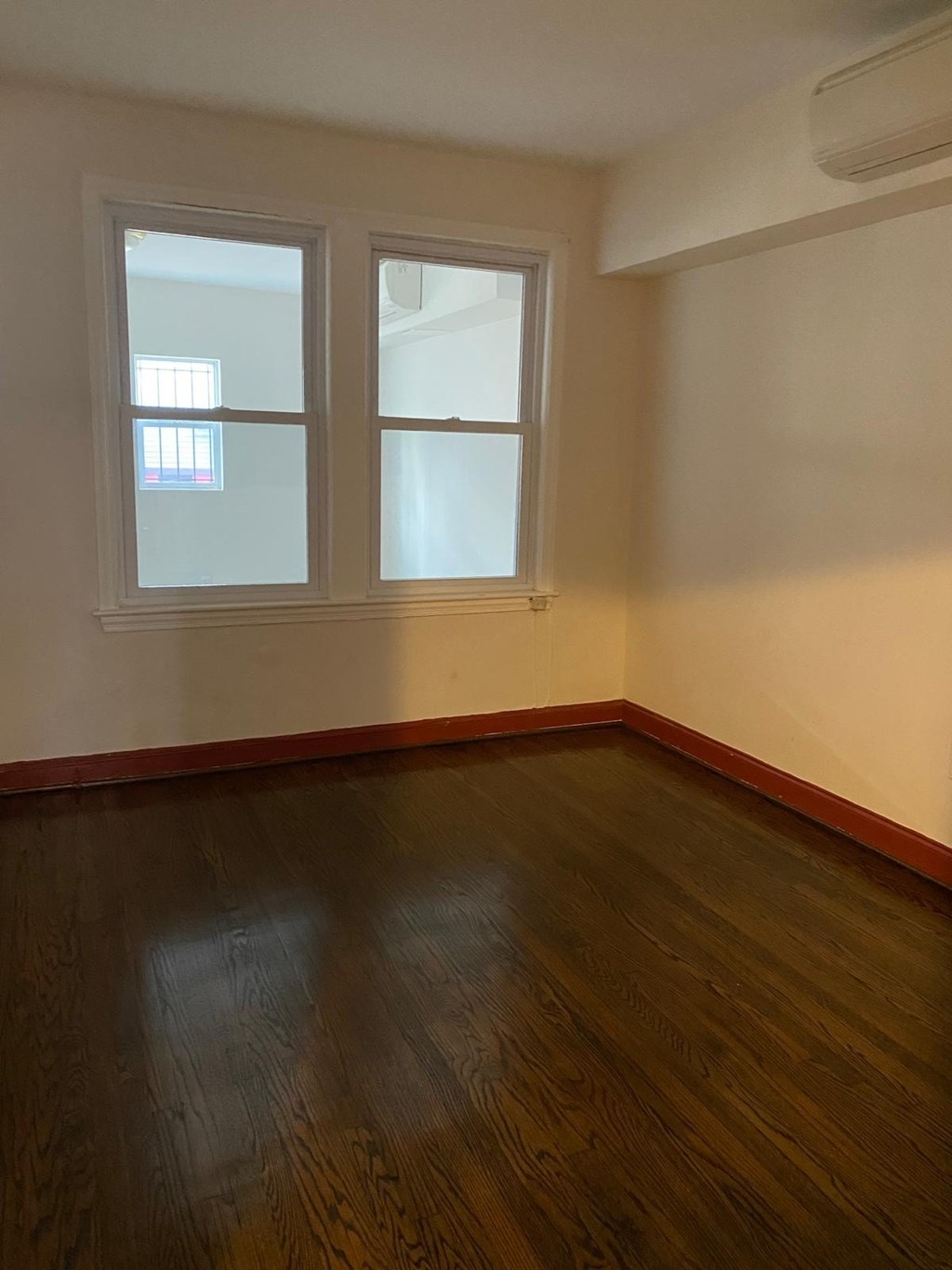 A room with a window and wooden floors.