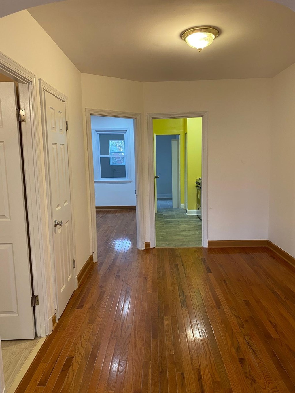 A hallway with wood floors and white walls.