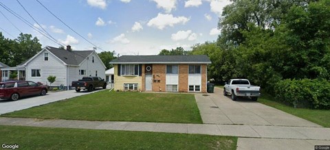 A house with a white garage door and a brown garage door.