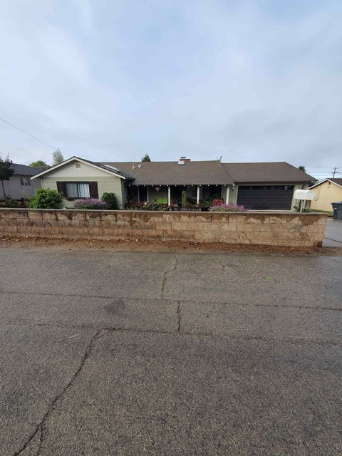 A house with a grey roof and a driveway in front.