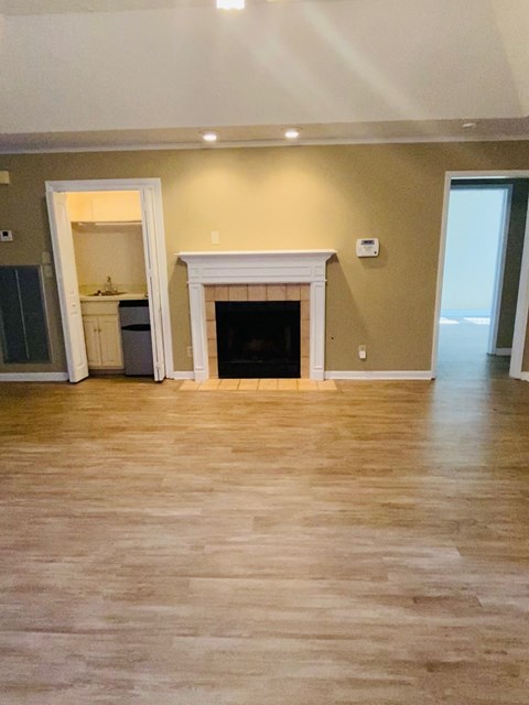 A living room with a fireplace and hardwood floors.