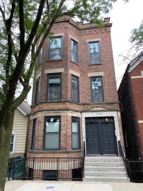 A brick building with a black door and windows.