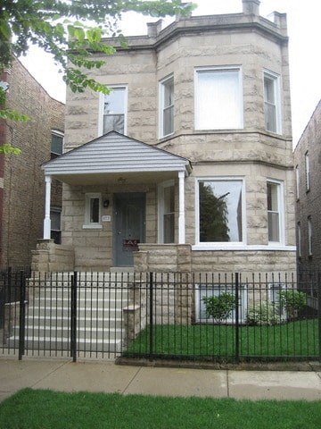 A house with a grey roof and a black fence.