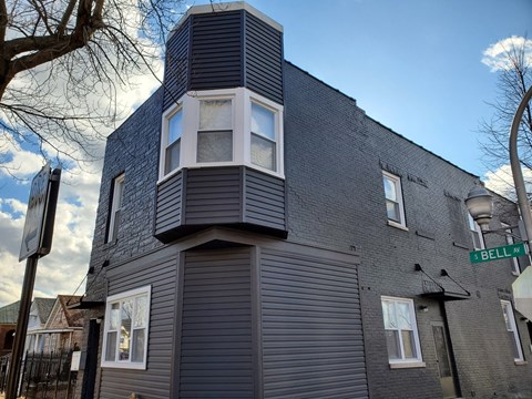 A modern building with a grey facade and a sign that reads "BELL RD".
