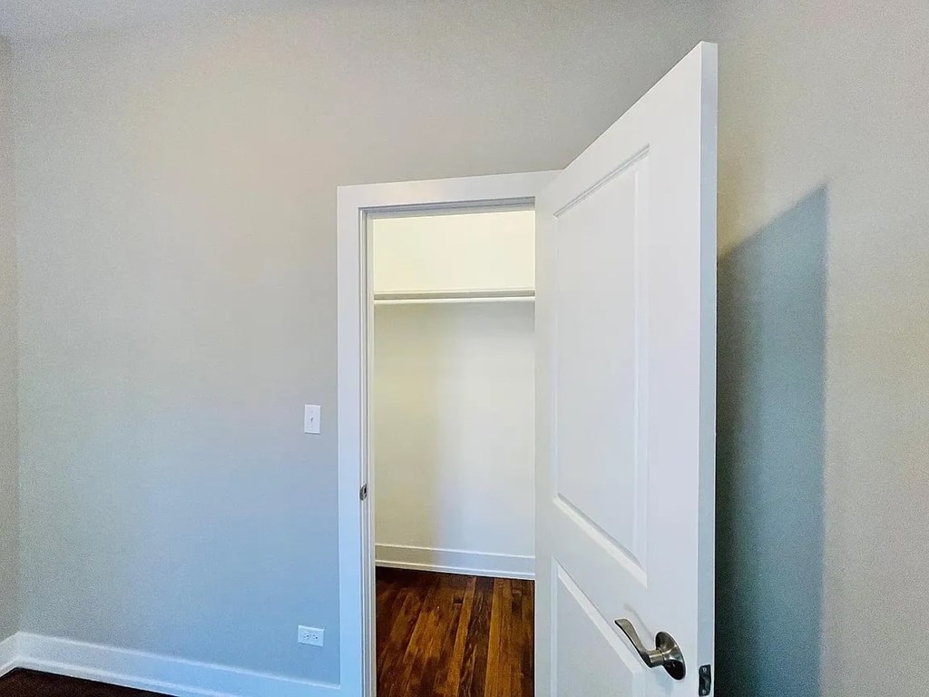 A white door is open to a room with a light on.