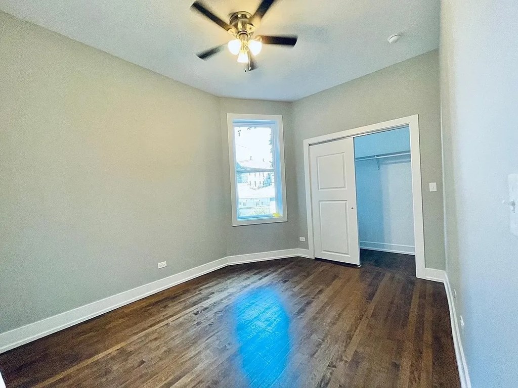 A room with a ceiling fan and a window.