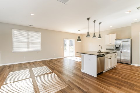 A kitchen with wooden floors and a white island.