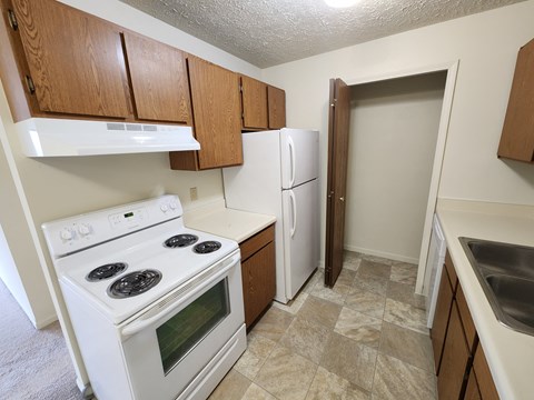 A kitchen with a white stove and a white refrigerator.
