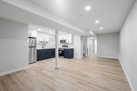 A spacious kitchen with a refrigerator, microwave, and oven.