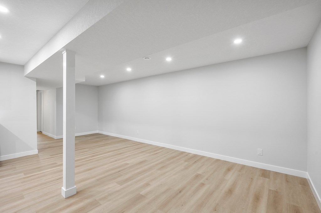 A room with wooden flooring and white walls.