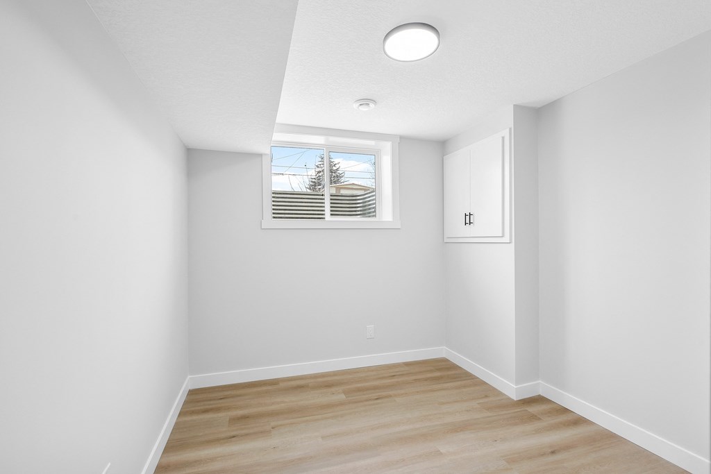 A room with a window and wooden flooring.