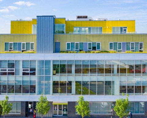 A modern building with a yellow and blue section on top.