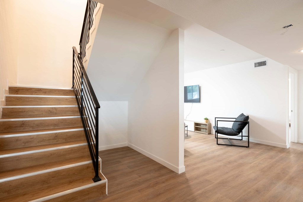 A living room with a couch and a television in the corner.