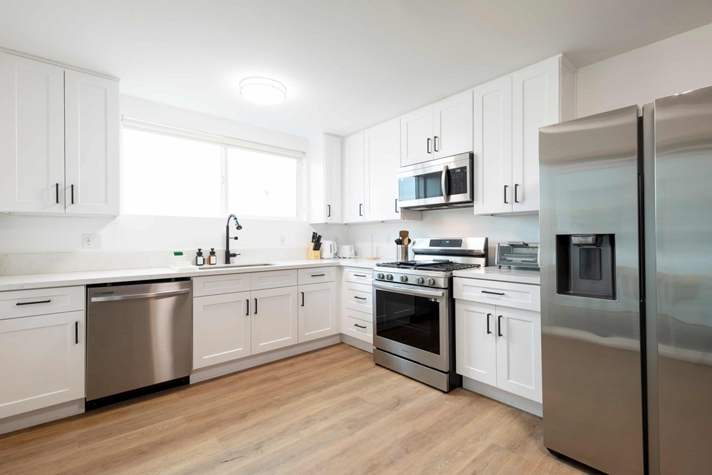 A kitchen with white cabinets and stainless steel appliances.