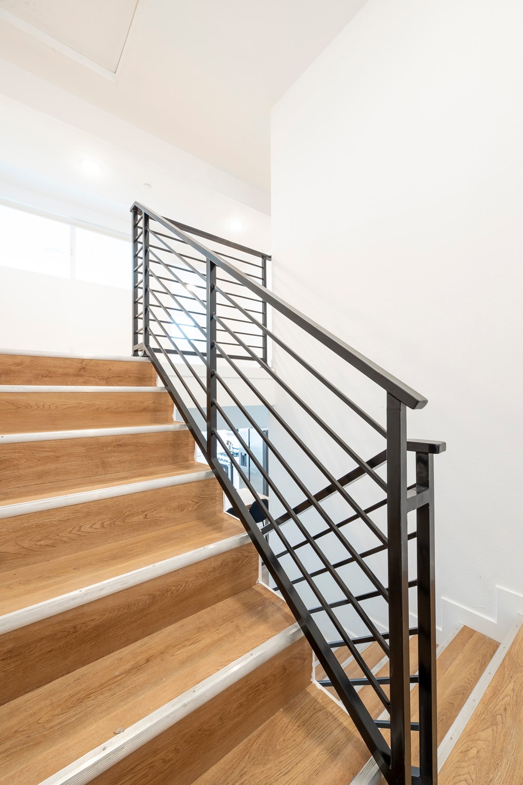 A staircase with a metal railing and wooden steps.