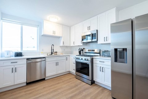 A kitchen with white cabinets and stainless steel appliances.