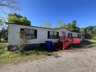 A white mobile home with a red staircase outside.