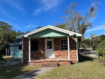 A small house with a white door and a green roof.