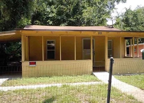 A small yellow building with a red sign on the front.