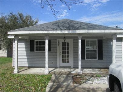 A small white house with a porch and a covered front door.