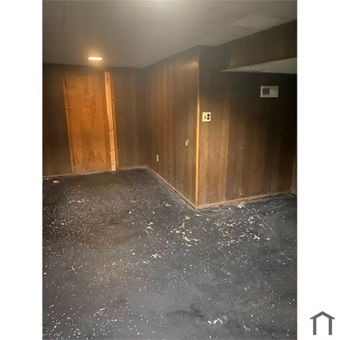 A room with wooden walls and a concrete floor.