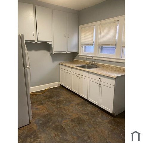 A kitchen with white cabinets and a granite countertop.