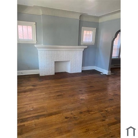A room with a fireplace and wooden floors.