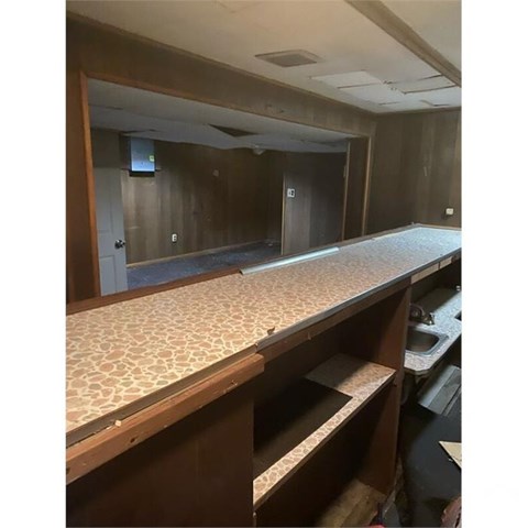 A room with a long counter and a sink.