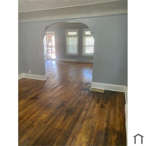 A room with wooden flooring and a window.