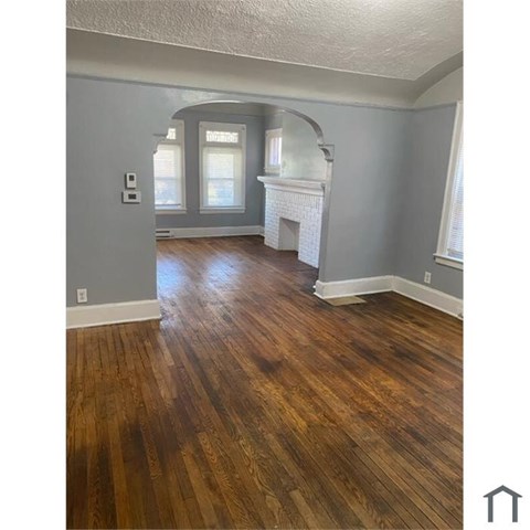 A room with wooden floors and a fireplace.