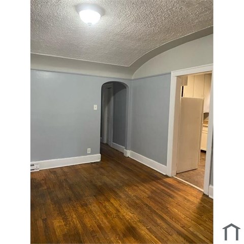 A room with wooden floors and a grey wall.