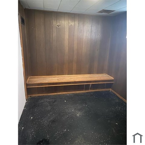 A wooden bench sits in a room with wooden walls.